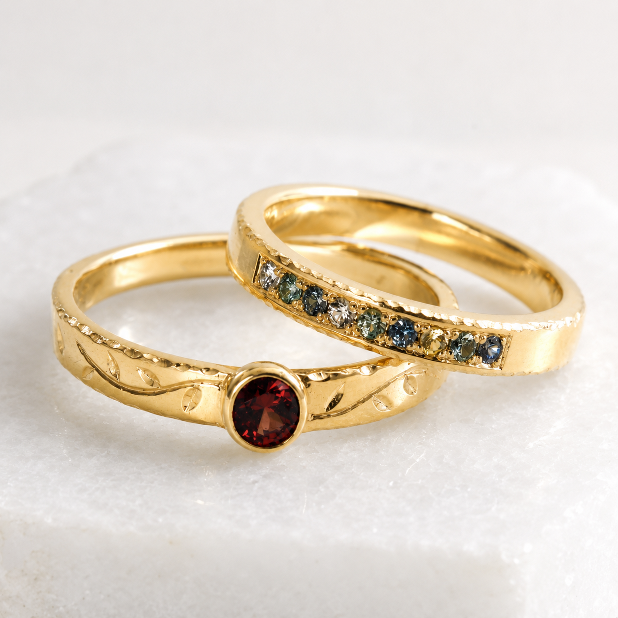 Coastal Stacking Ring in 14K gold with Montana Sapphires and Tendril Stacking Ring with a Malaya Garnet and hand engraving in 14K gold