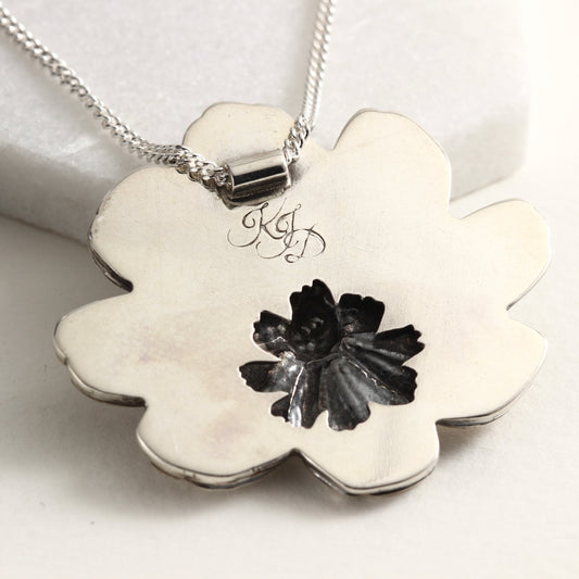 Back view of Wild Radiance Cosmos Pendant, a handcrafted flower necklace, showing cut out detail