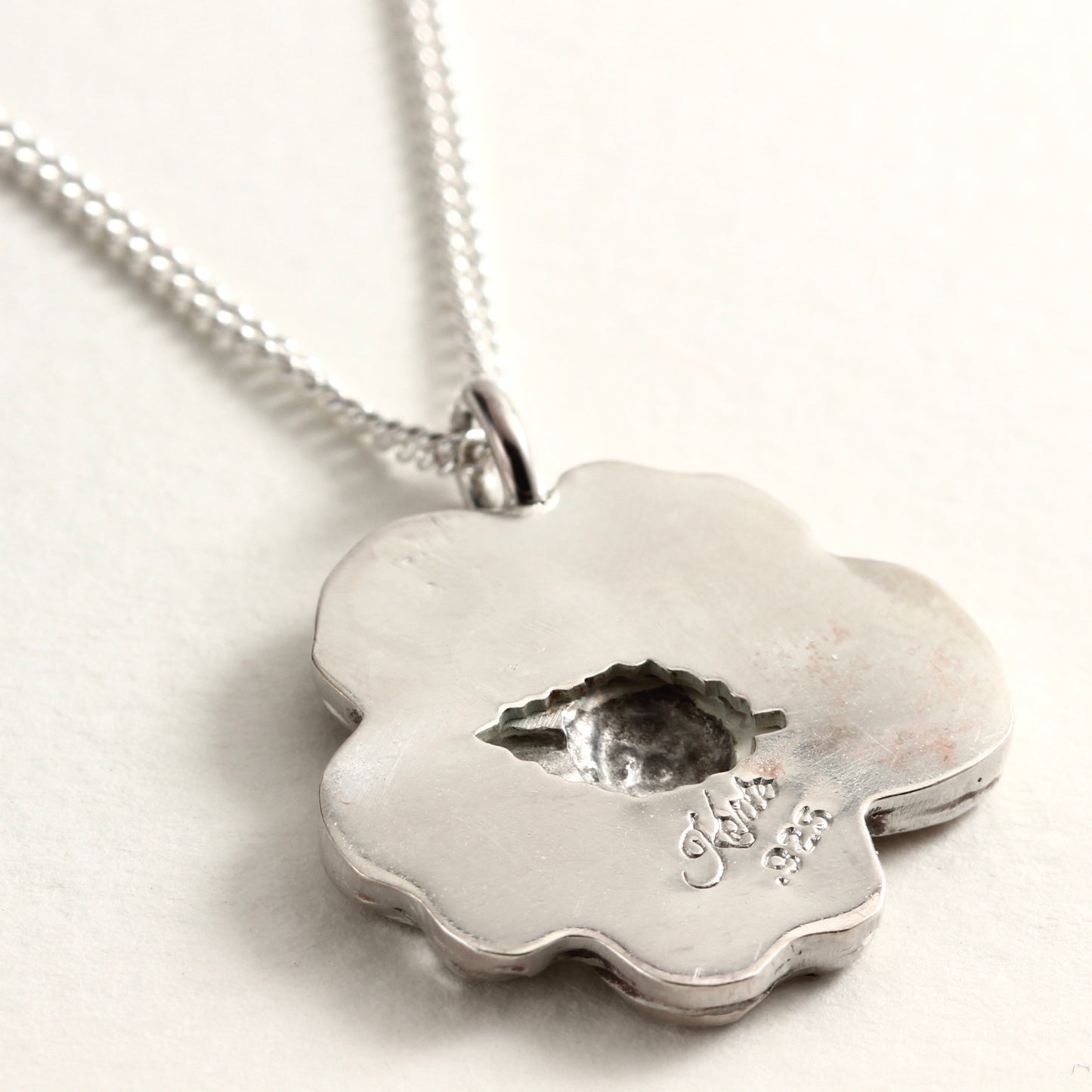 Back detail, showing leaf shape, of Wild Bloom Pendant, handcrafted flower necklace on white background