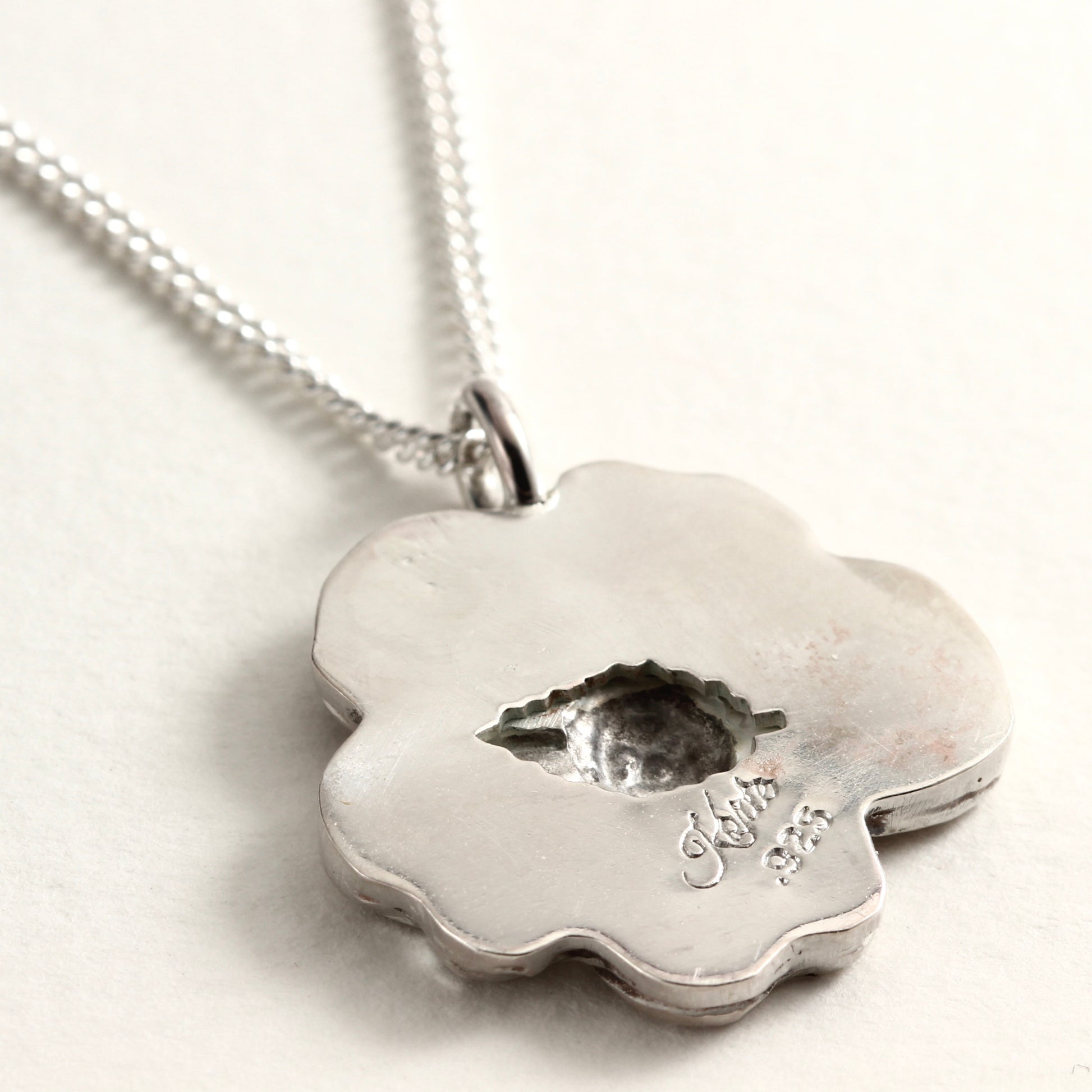 Back detail, showing leaf shape, of Wild Bloom Pendant, handcrafted flower necklace on white background