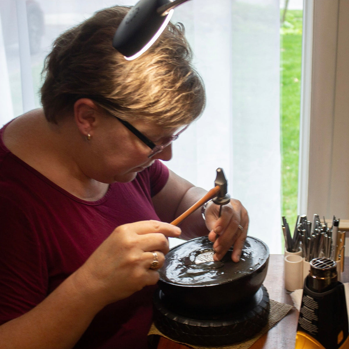 An image showing the artist working on chasing and repousse