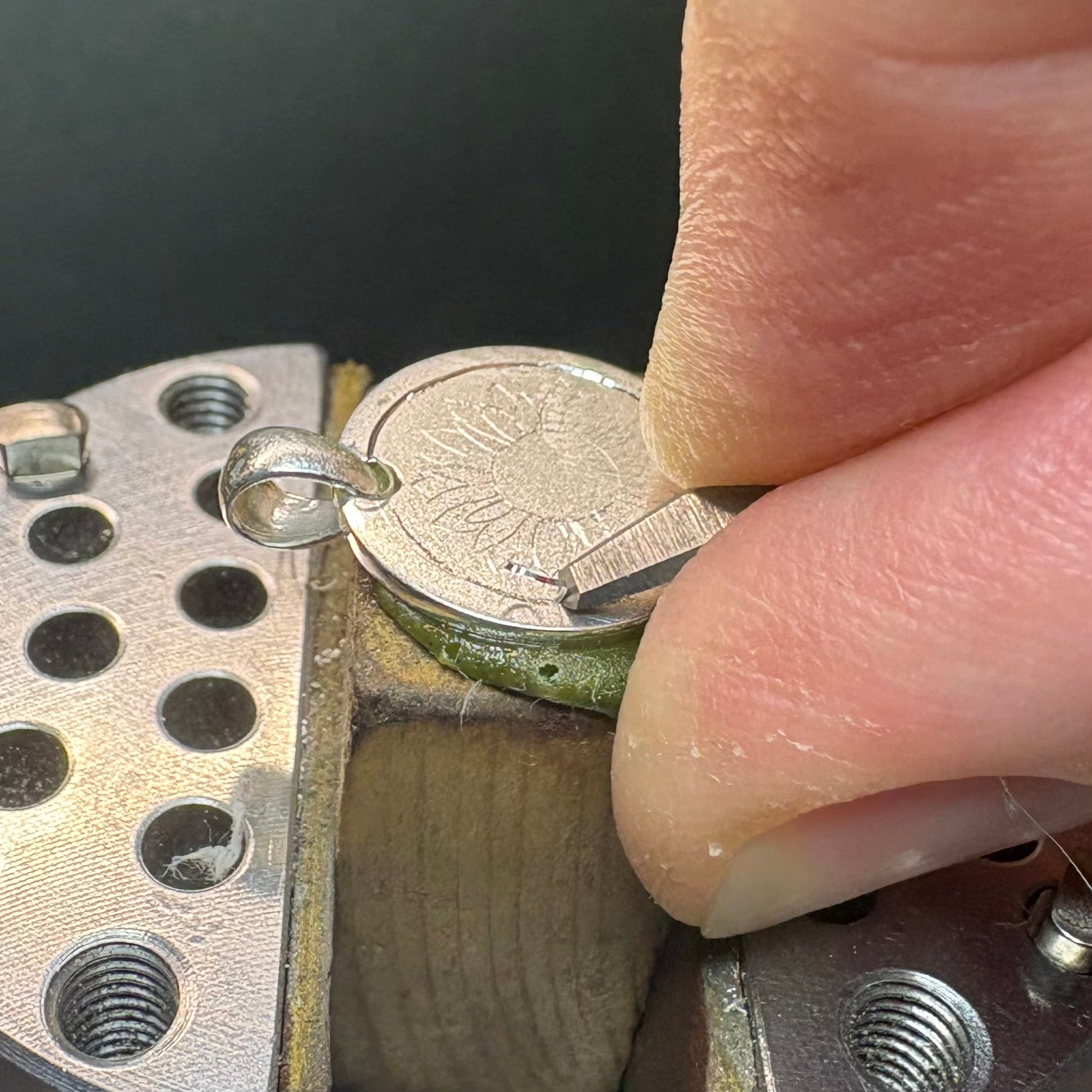 Close-up of the engraving process showing a small chip of metal being pushed up