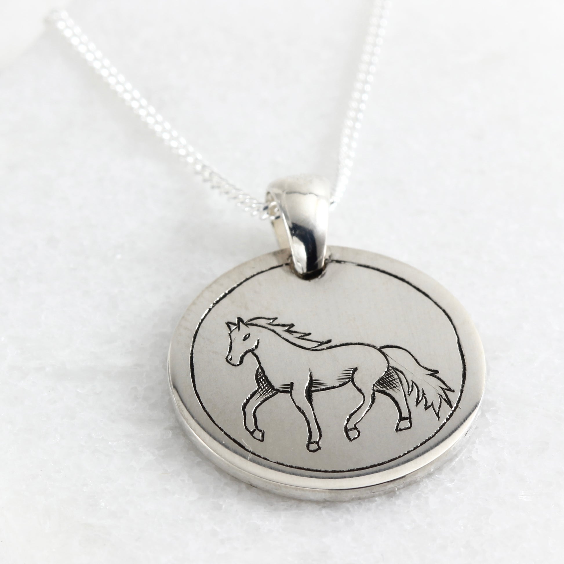 Small hand-engraved sterling silver pendant featuring a horse