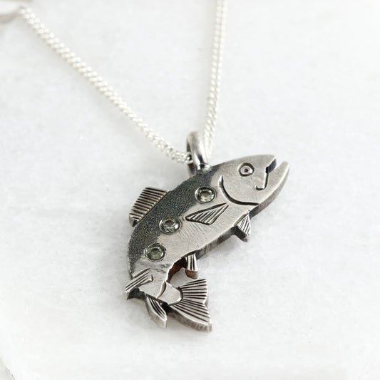 Sterling silver hand-fabricated jumping trout pendant with three shimmering Montana sapphires.