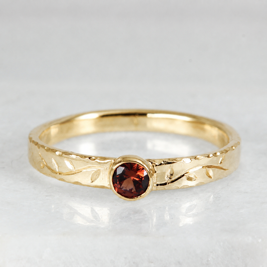 Front view of the Tendril Solitaire Ring in 14k gold, showing the gemstone and the hand engraved vine.