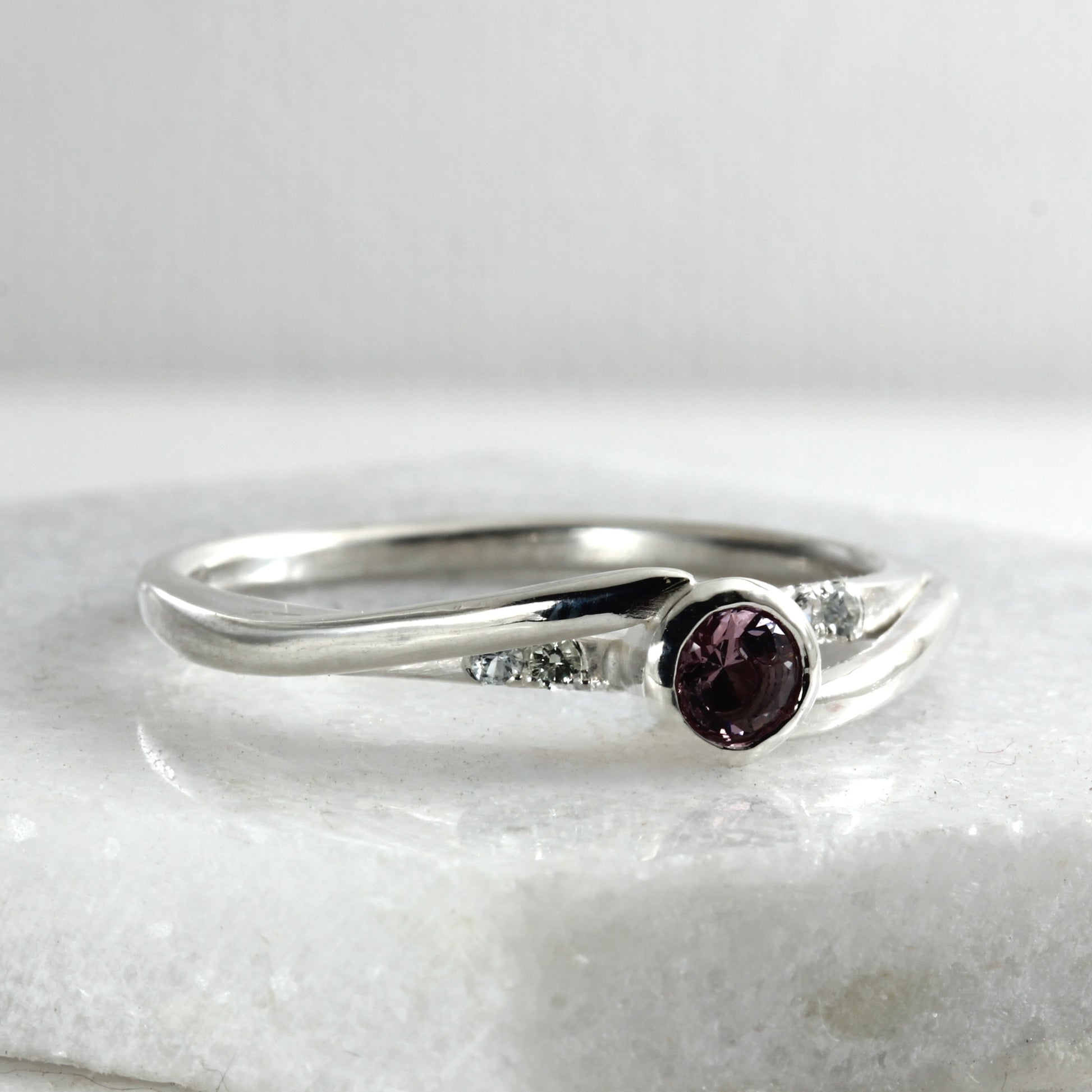 Side view of a sterling silver solitaire ring featuring a large garnet and four small Montana sapphires.