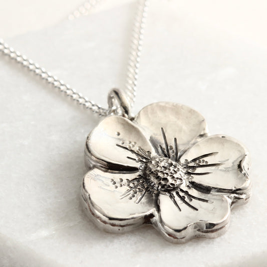 Wild Bloom Pendant in sterling silver, handcrafted flower necklace on white marble