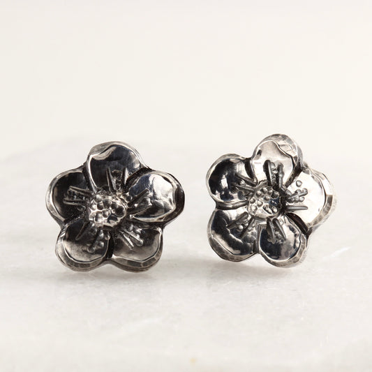 Wild Bloom Stud Earrings in sterling silver, handcrafted floral studs, on marble background