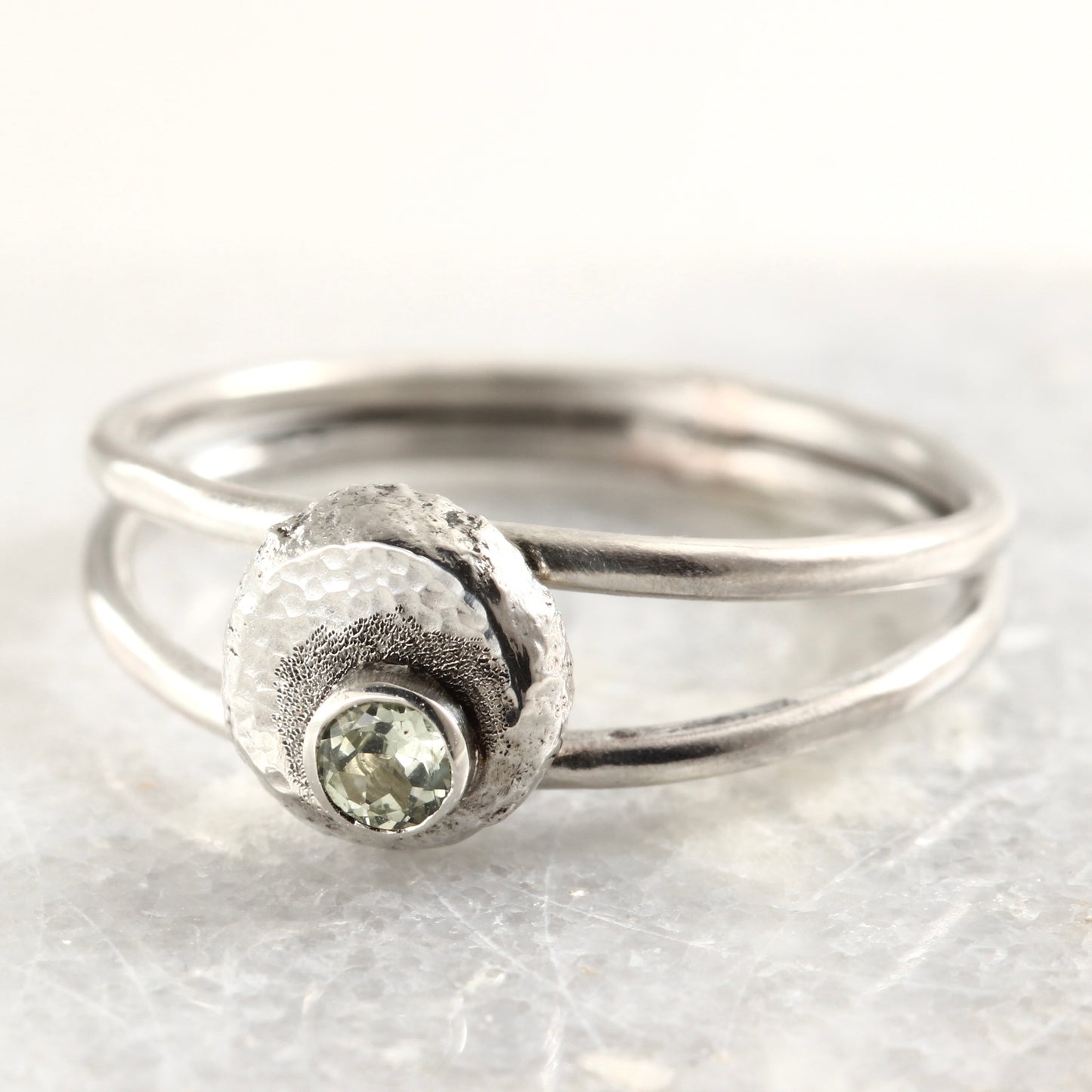 Wild Bud Ring in sterling silver with Montana sapphire, shown on a white marble tile