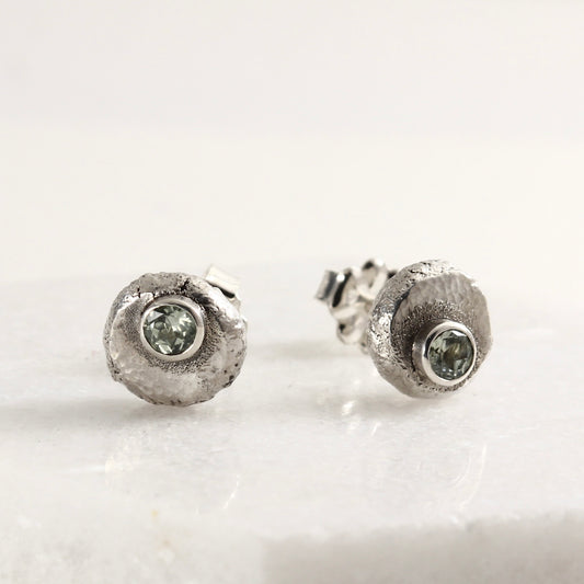 Wild Bud Stud Earrings in sterling silver with Montana sapphires, shown on a white marble tile