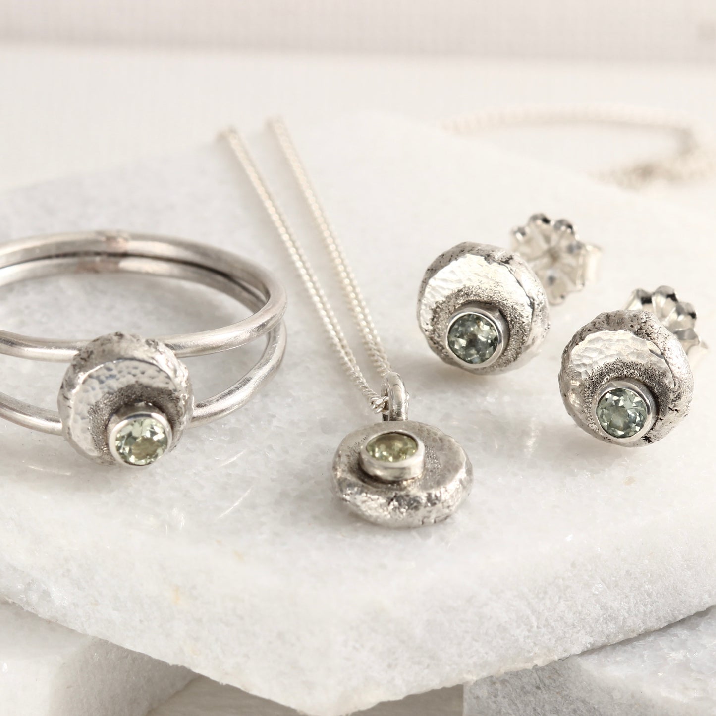 A group of jewelry from the Wild Buds series, sterling silver with Montana sapphires, shown on white marble tile