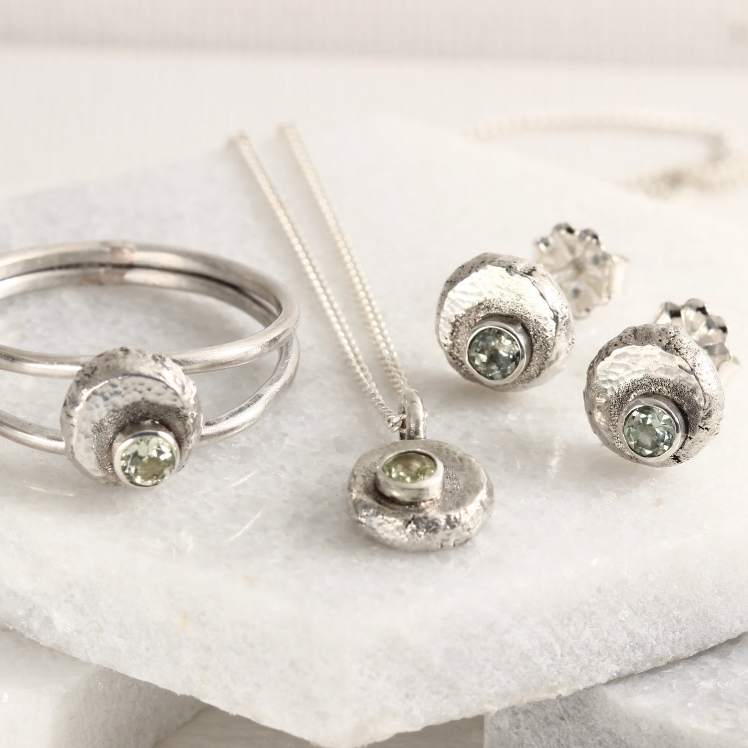 A group of jewelry from the Wild Buds series, sterling silver with Montana sapphires, shown on white marble tile