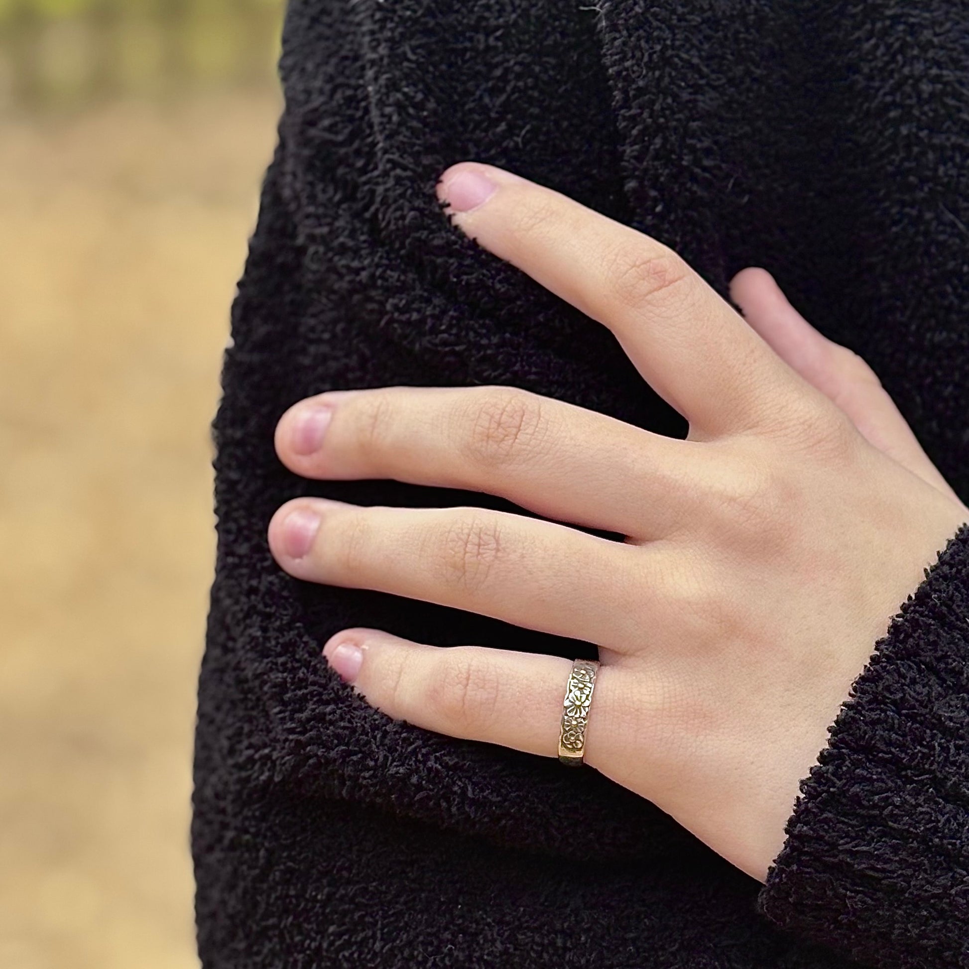 Wild Meadow Half band in sterling silver with gold accents, a hand carved flower ring shown on a model