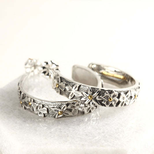 Wild Meadow Hoop Earrings in sterling silver with gold accents, hand carved earrings on a white marble background