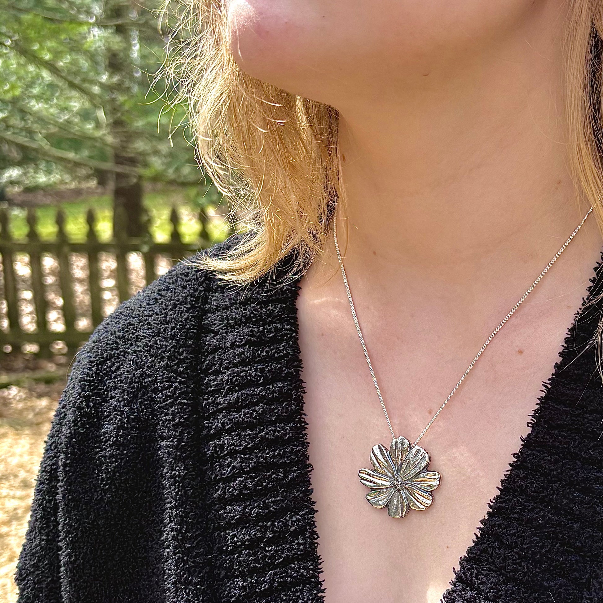 Wild Radiance Cosmos Pendant in sterling silver, a handcrafted flower necklace shown on a model