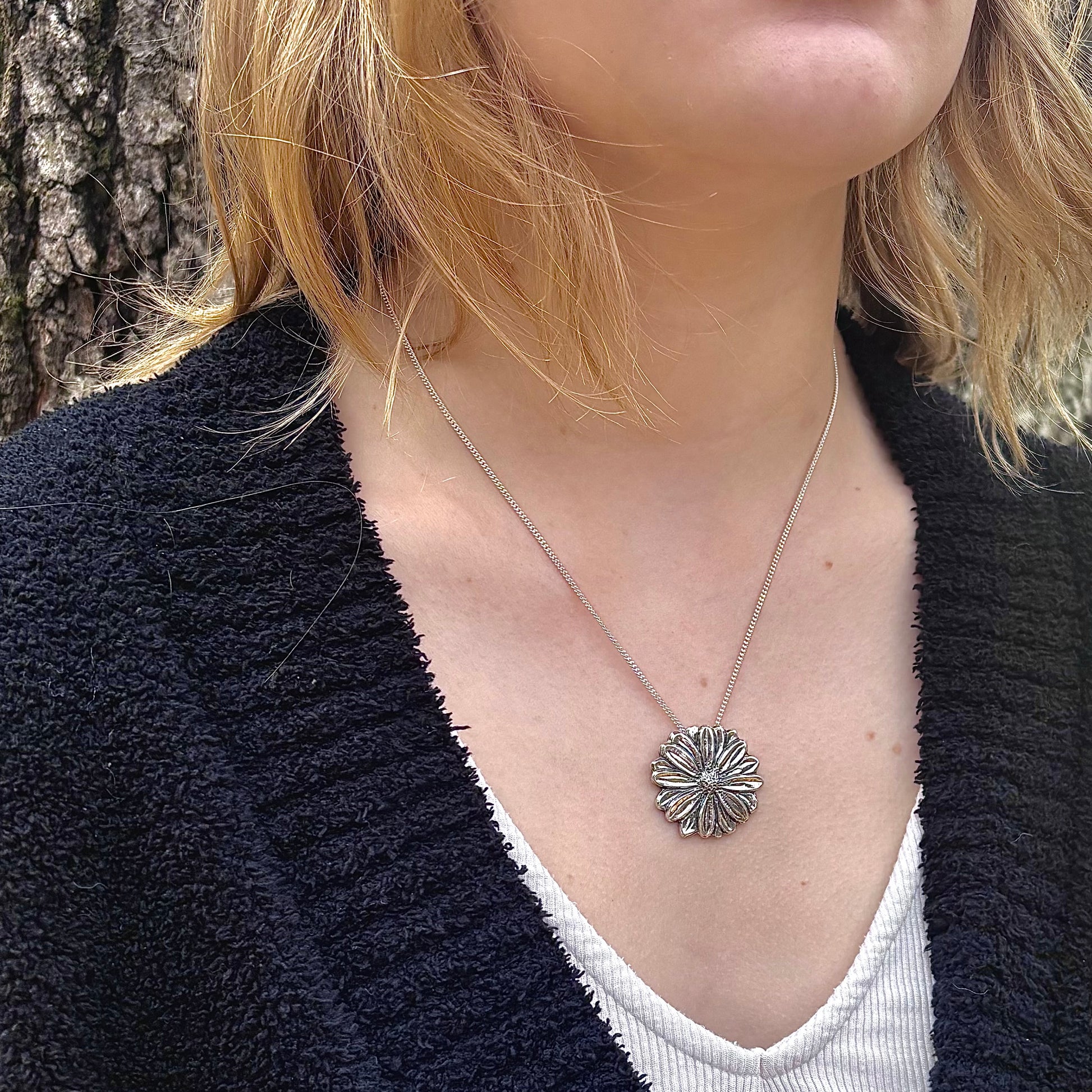 Wild Radiance Daisy Pendant in sterling silver, handcrafted flower necklace, shown on model