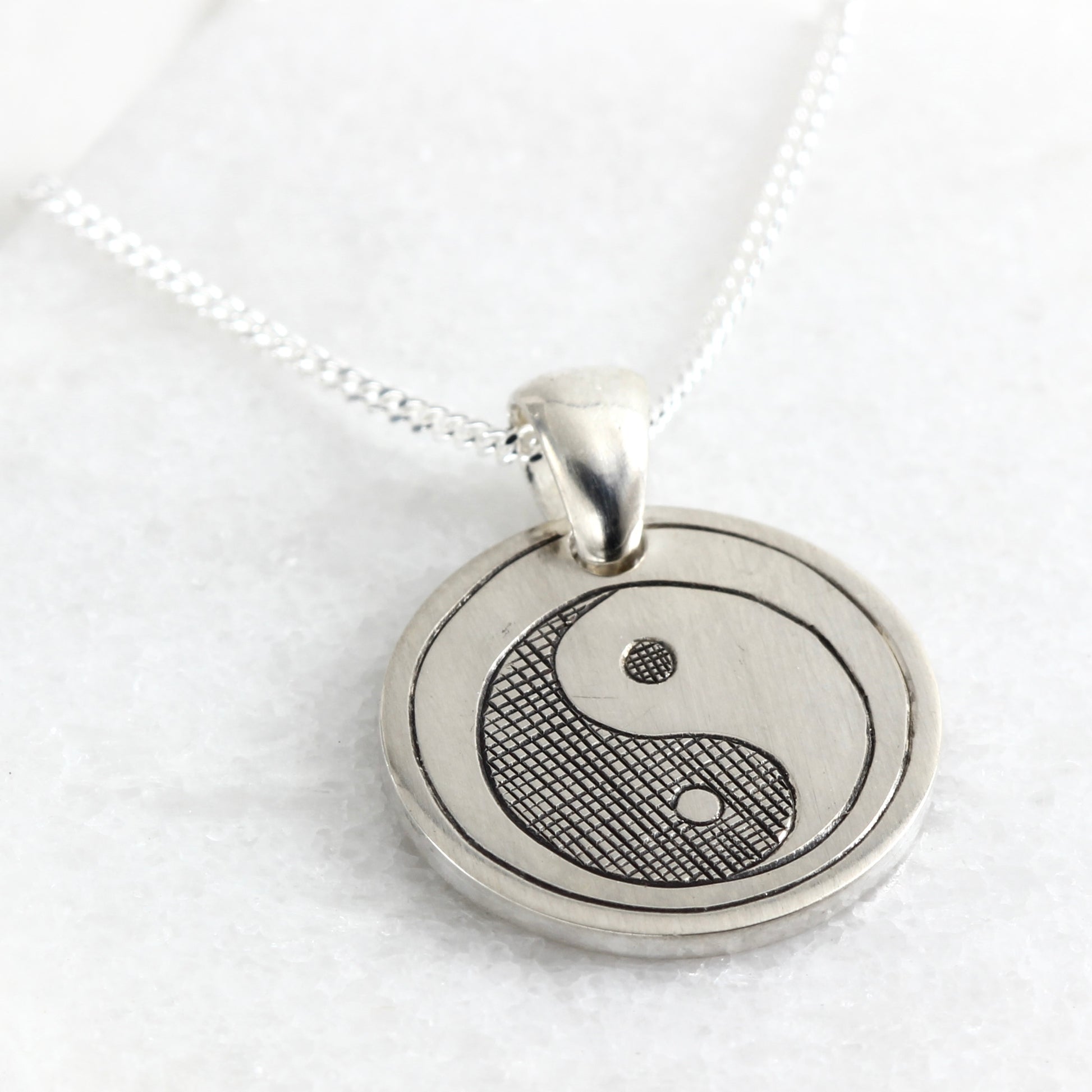 Small hand-engraved sterling silver pendant featuring a yin and yang
